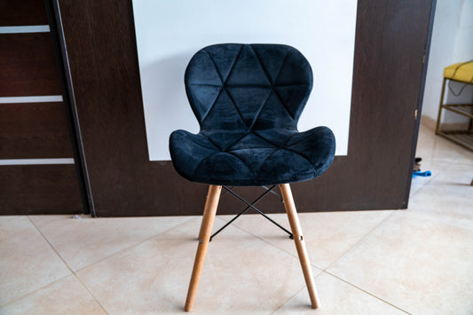 Blue chair with wooden legs on a tiled floor